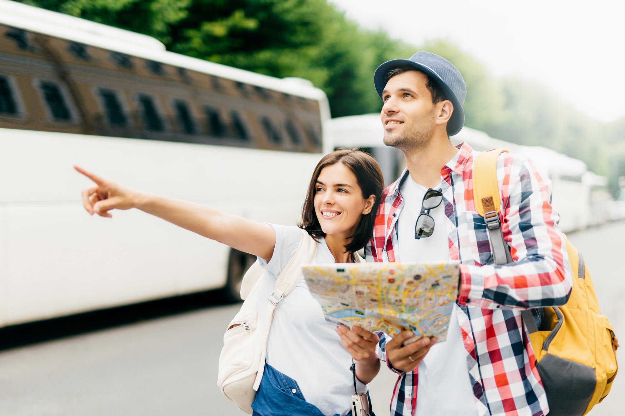 Couple having vacations, looking in city map, pointing at destination, exploring new locations